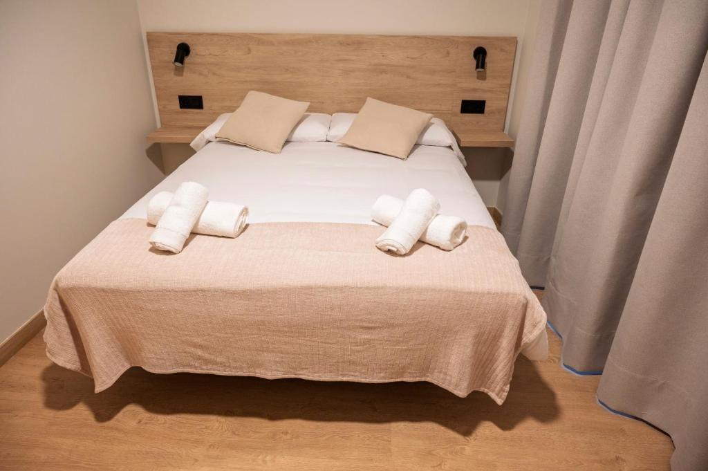 Habitación doble proyecto reforma integral apartamentos Meile en León. Habitación cama matrimonio, manta rosa.