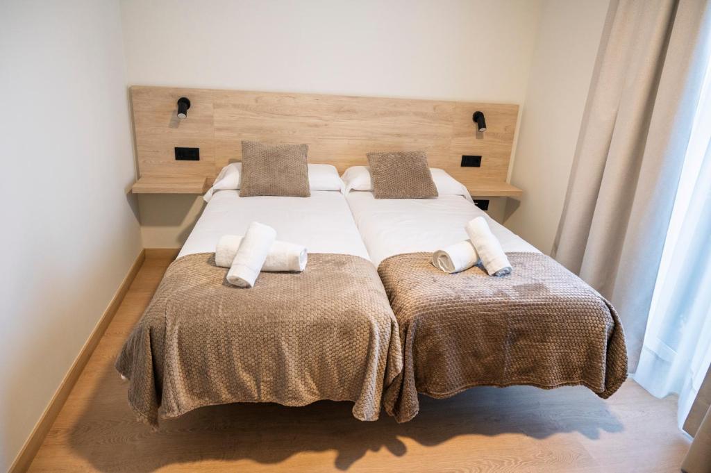 Habitación doble proyecto reforma integral apartamentos Meile en León. Habitación cama doble con manta marrón.