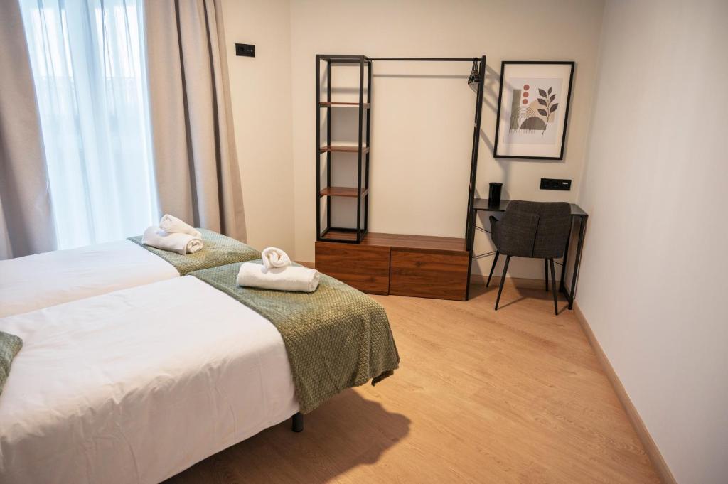 Habitación doble proyecto reforma integral apartamentos Meile en León. Habitación cama doble con manta verde. Detalles